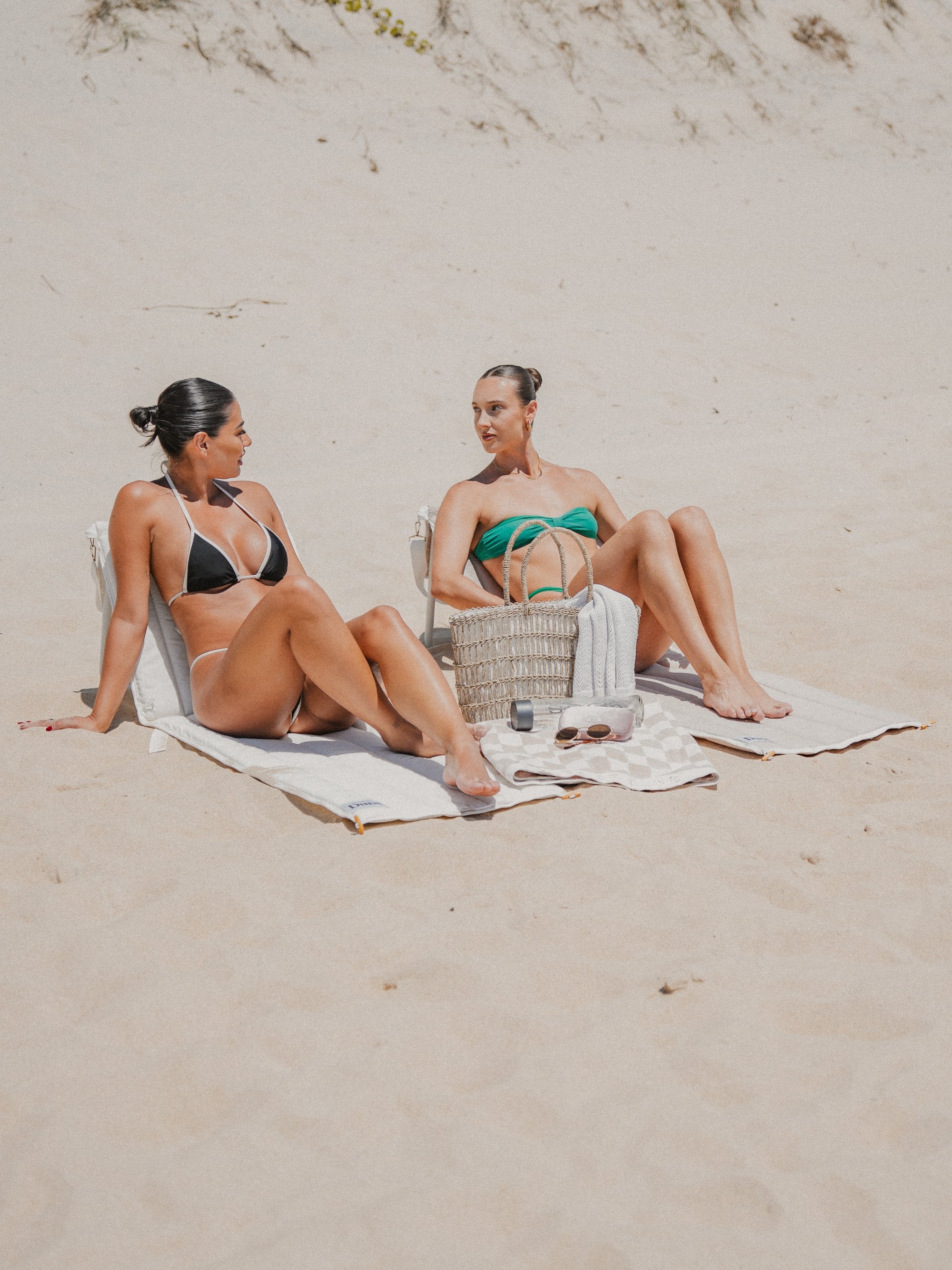 Two friends on Beach Loungers on the sand
