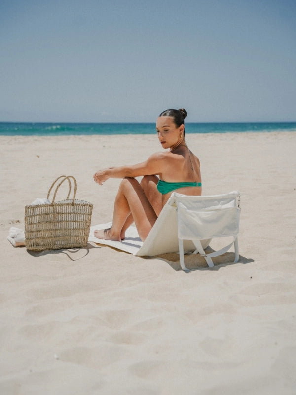 Oyster Tide foldable beach lounger by House of Dune, crafted from recycled RPET, positioned on soft sand with ocean views for relaxed coastal lounging.