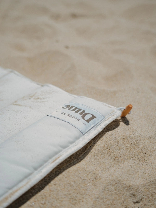 Close-up of House of Dune Sand Drift beach lounger fabric and label, highlighting durable recycled RPET material designed for sustainable coastal living.