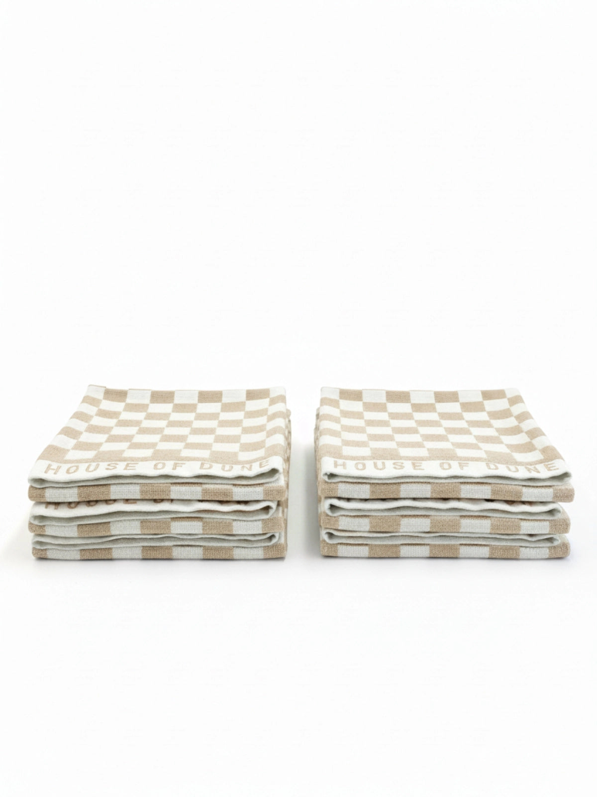 Six House of Dune Sand Drift beach towels folded in two stacks, showing the beige and white checkerboard pattern for a minimalist, coastal aesthetic.