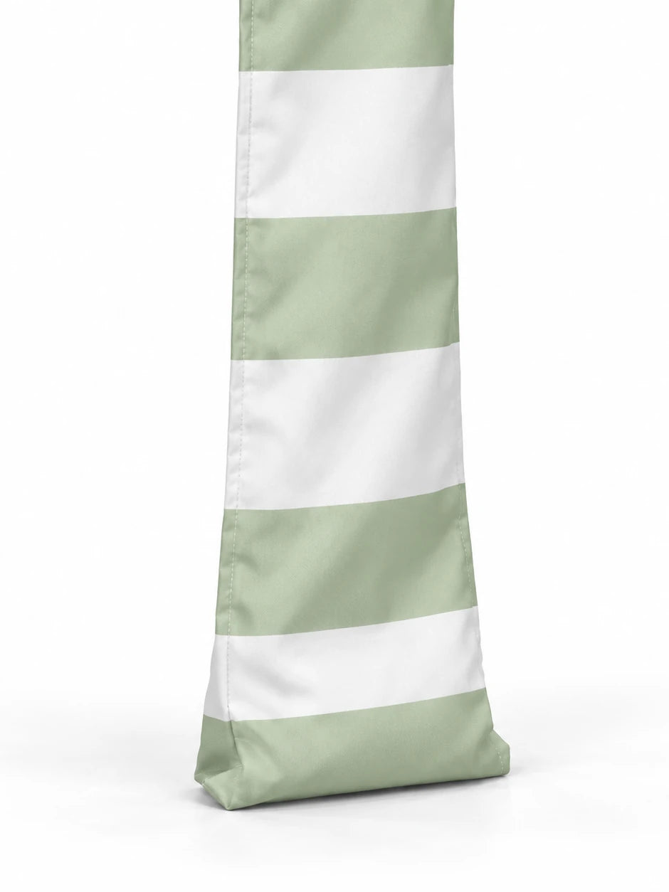 Foot of a House of Dune Salted Sage cabana leg: soft sage and white striped fabric with a stitched base that sits on the sand.