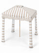 House of Dune Sand Drift beach cabana from a raised three-quarter angle, showing the striped roof panels, central vent, fringe and four fabric legs.