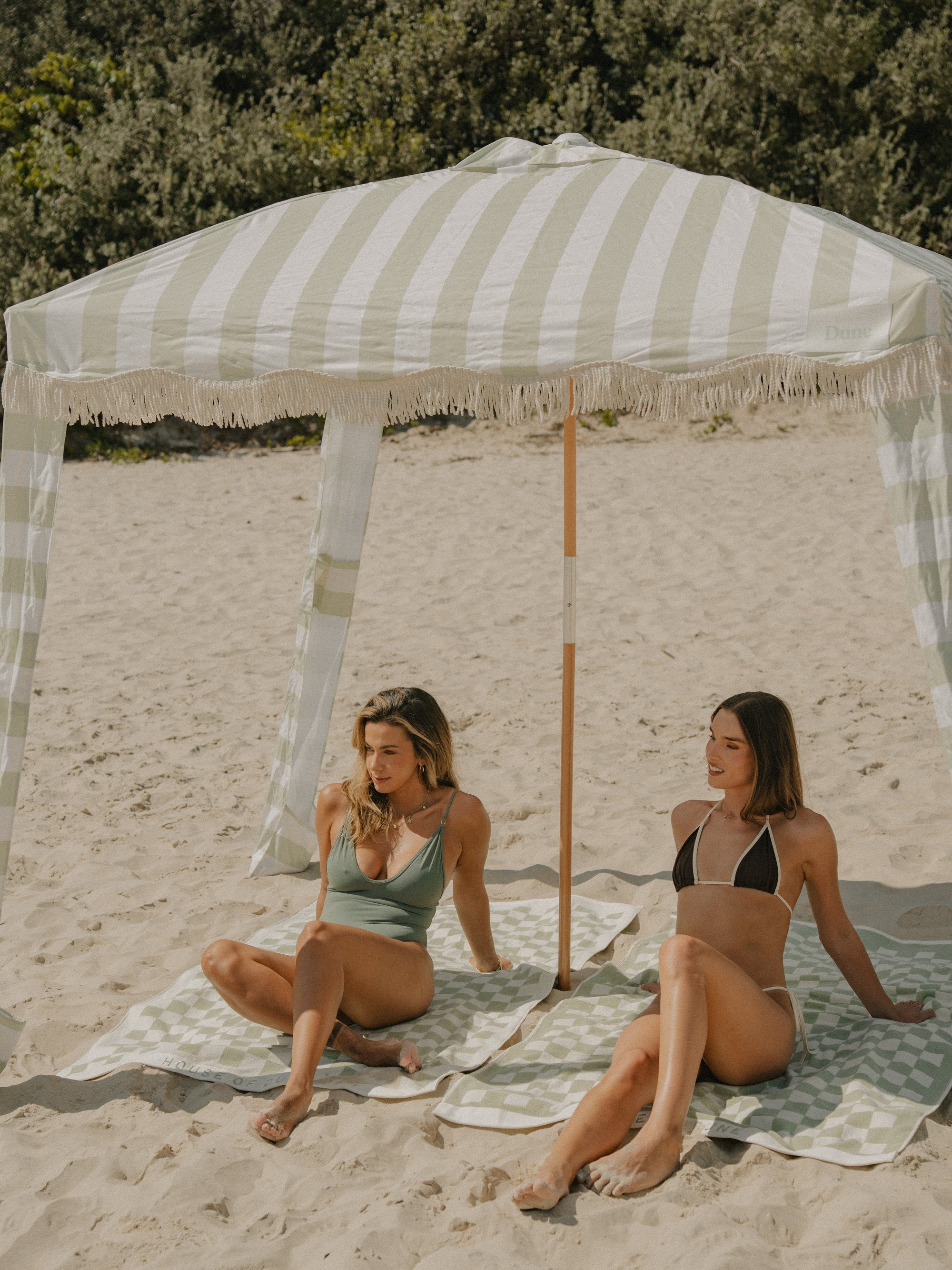 Two friends relaxing under a Salted Sage Beach Cabana
