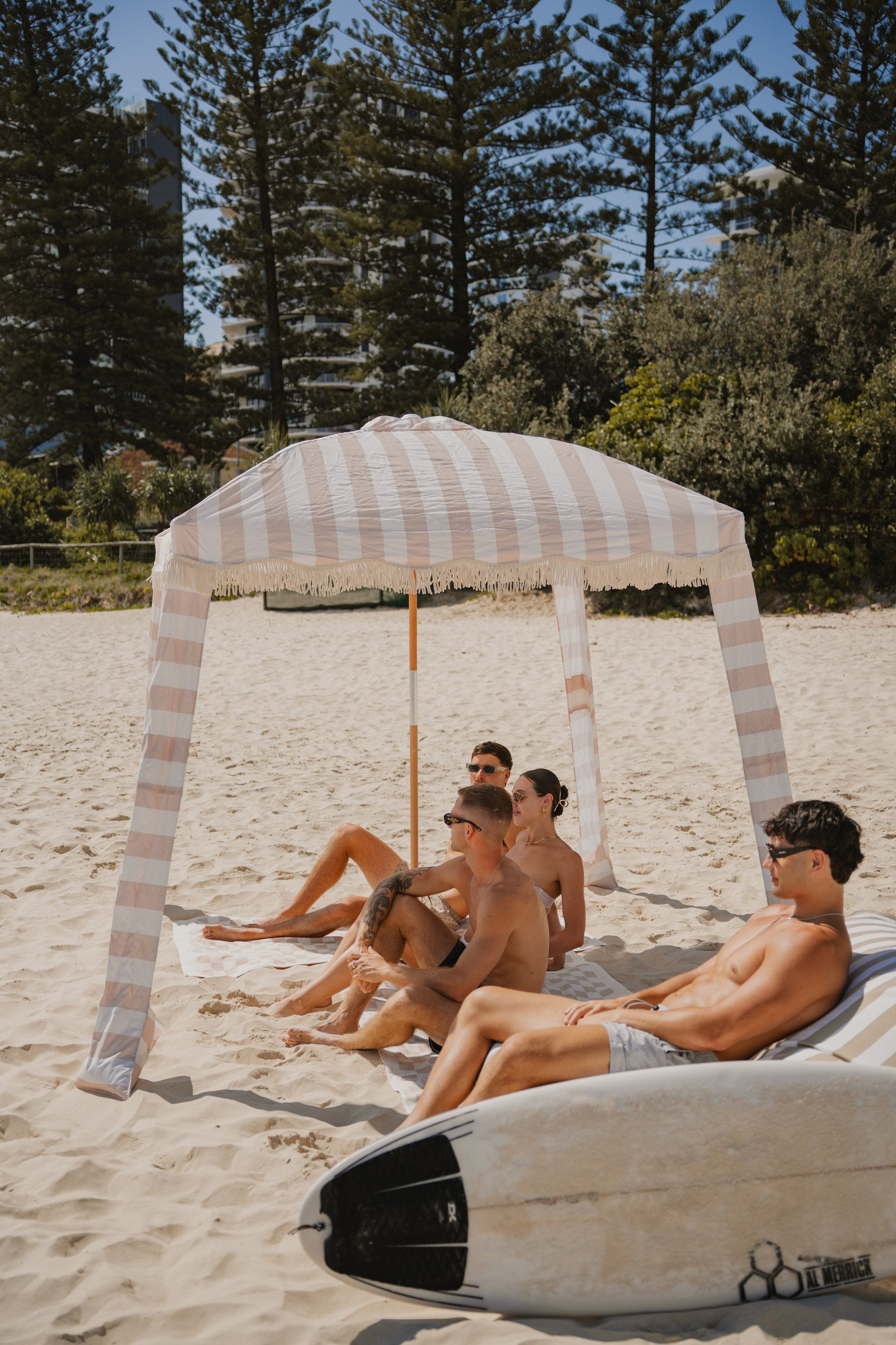 Friends relaxing under a Sand Drift Beach Cabana