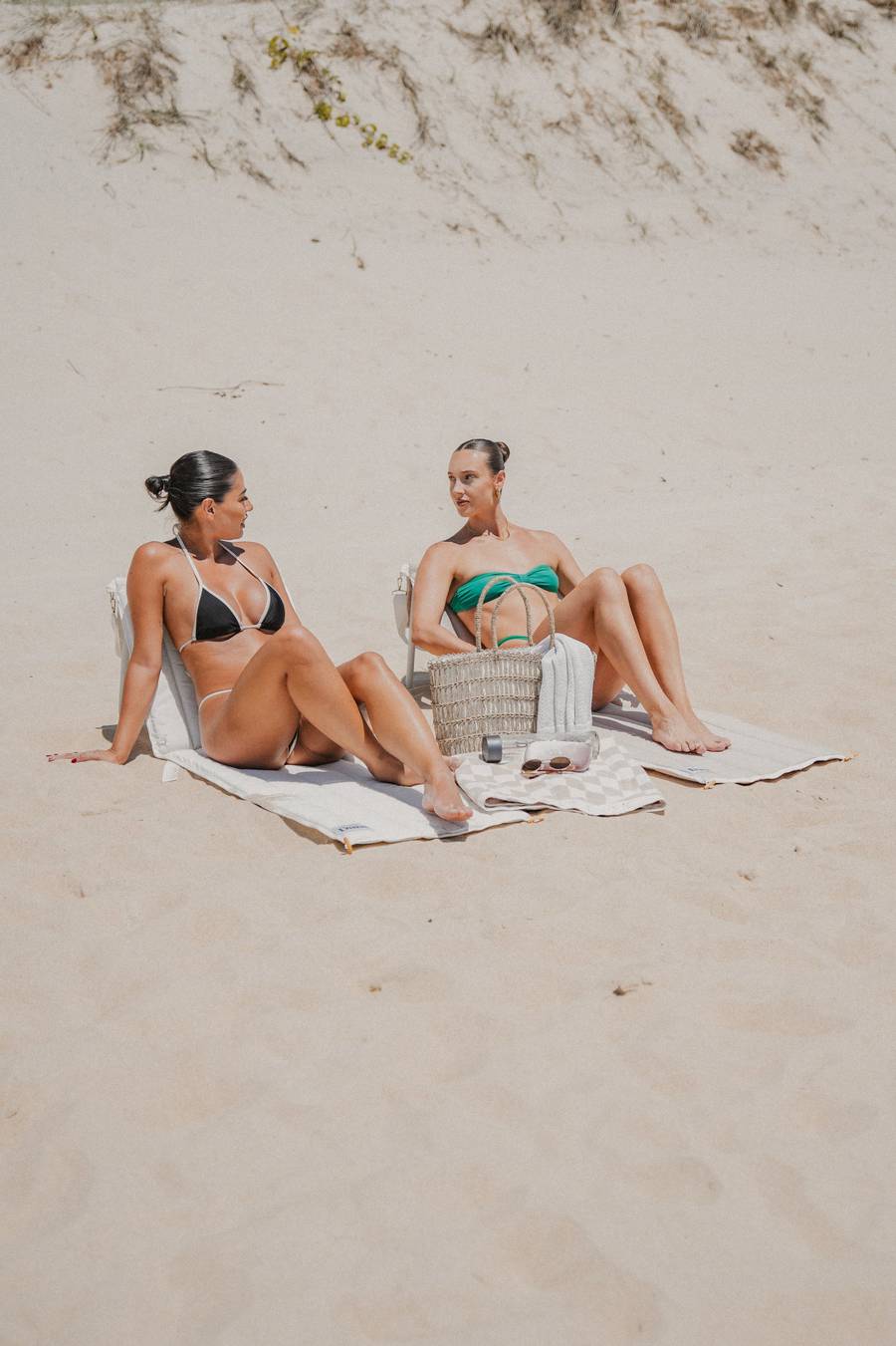 Two friends on Beach Loungers on the sand