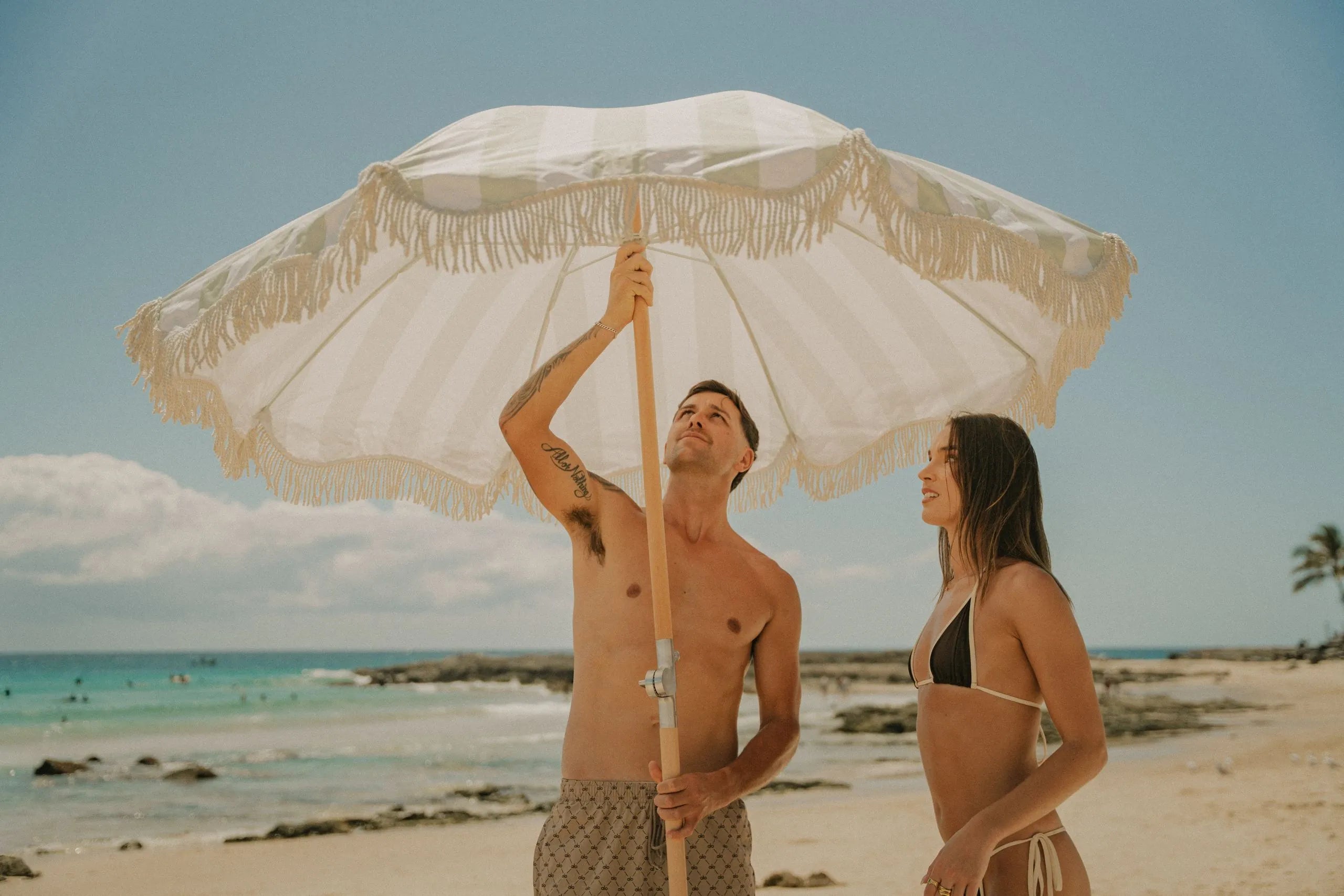 A couple opening a Beach Umbrella on the beach