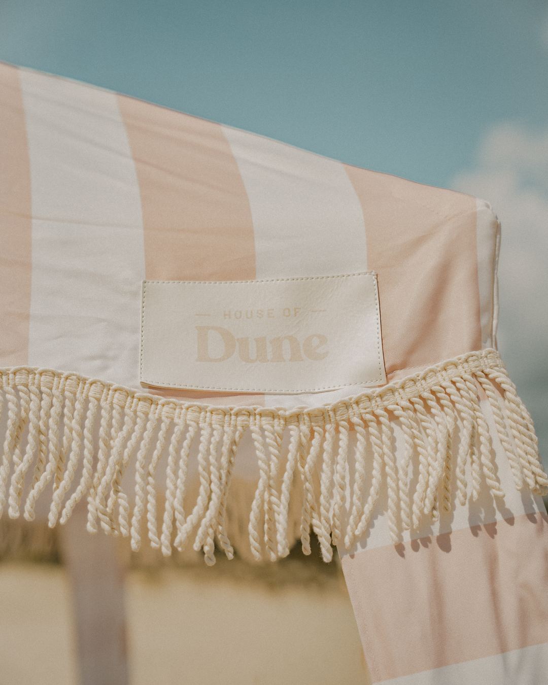 The woven Dune label and cotton fringe on a Beach Cabana in Sand Drift